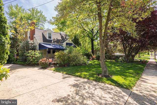 view of home's exterior with a lawn, a chimney, and a shingled roof