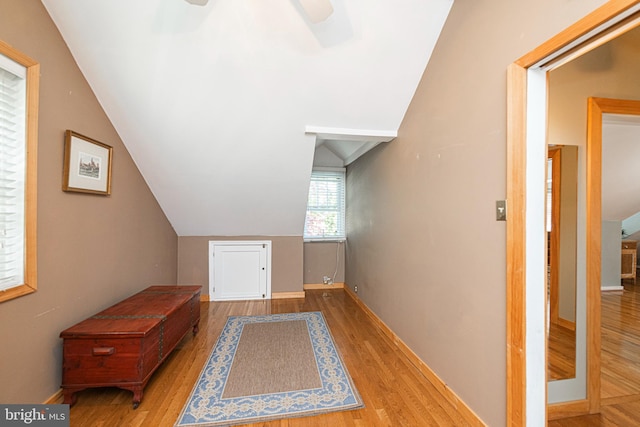 additional living space with wood finished floors, a ceiling fan, vaulted ceiling, and baseboards