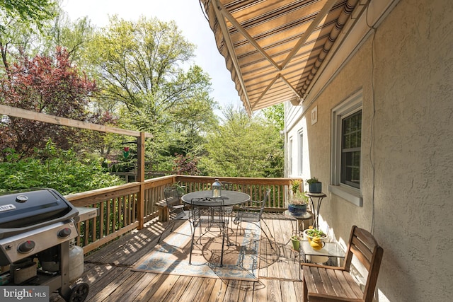wooden terrace with area for grilling and outdoor dining space