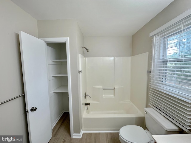 full bath featuring wood finished floors, toilet, and shower / bathtub combination