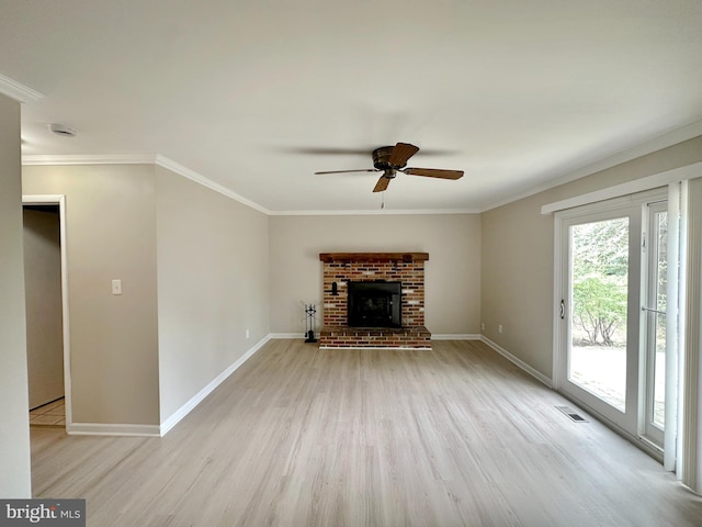 unfurnished living room featuring light wood-style flooring, ceiling fan, baseboards, crown molding, and a brick fireplace