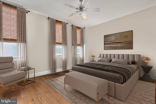 bedroom with wood finished floors, baseboards, and ceiling fan