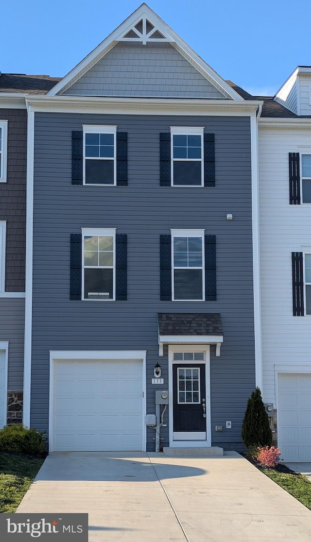 multi unit property with concrete driveway and an attached garage