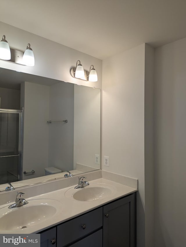 bathroom featuring double vanity and a shower stall