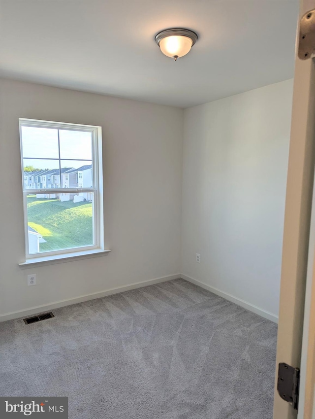 unfurnished room featuring carpet floors and baseboards