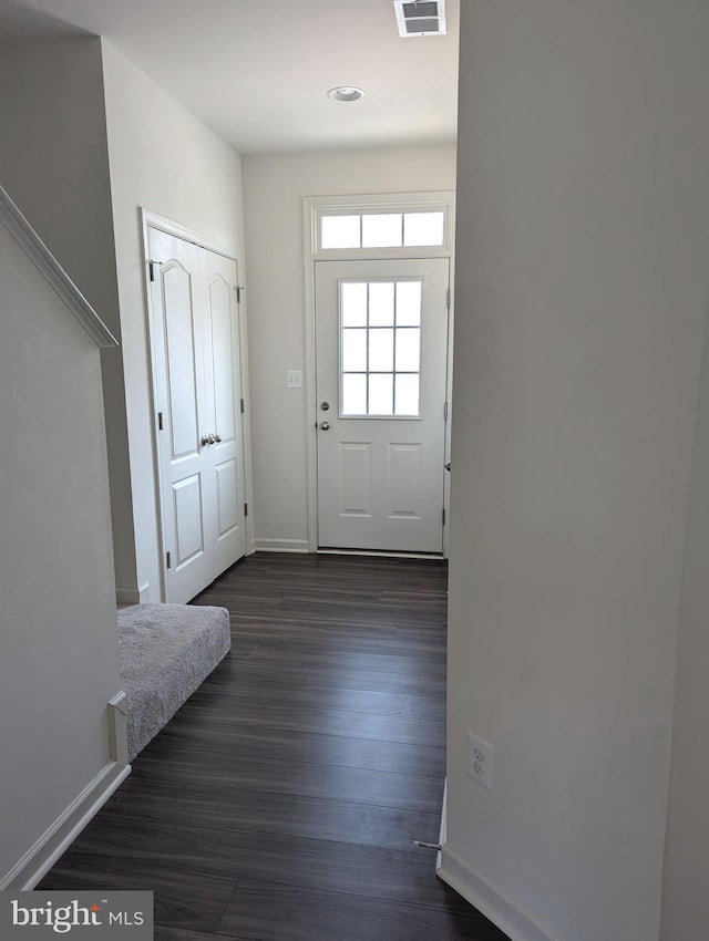 entryway with baseboards and dark wood-type flooring