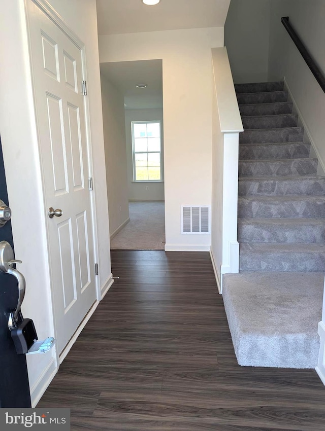 staircase featuring wood finished floors and baseboards