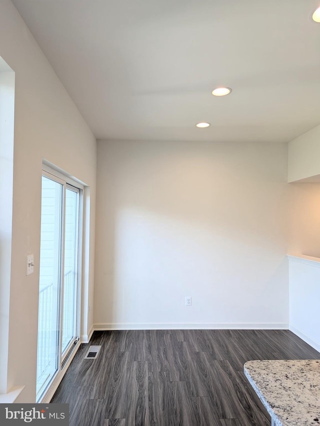 unfurnished dining area with dark wood-style floors, baseboards, and recessed lighting
