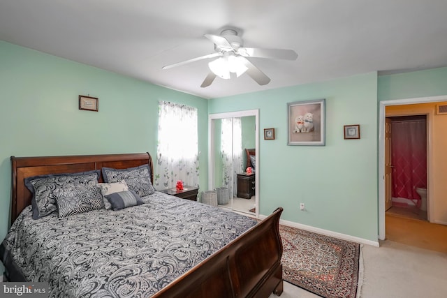 bedroom featuring light carpet, baseboards, a ceiling fan, and a closet