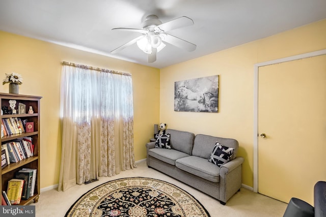 living area with carpet, a ceiling fan, and baseboards