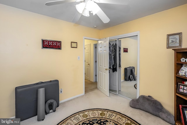 carpeted bedroom featuring a closet, ceiling fan, and baseboards