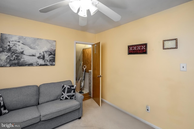 living area featuring a ceiling fan, carpet floors, and baseboards