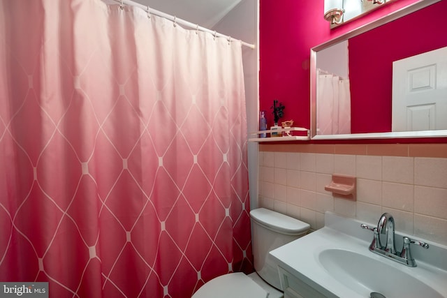 bathroom featuring tile walls, toilet, vanity, and a shower with shower curtain