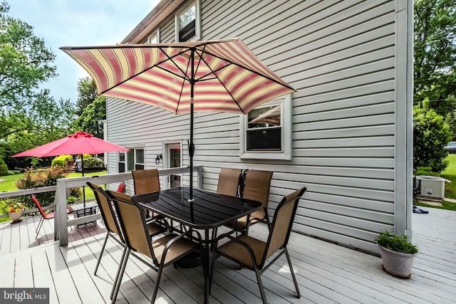 wooden terrace with outdoor dining area and central air condition unit