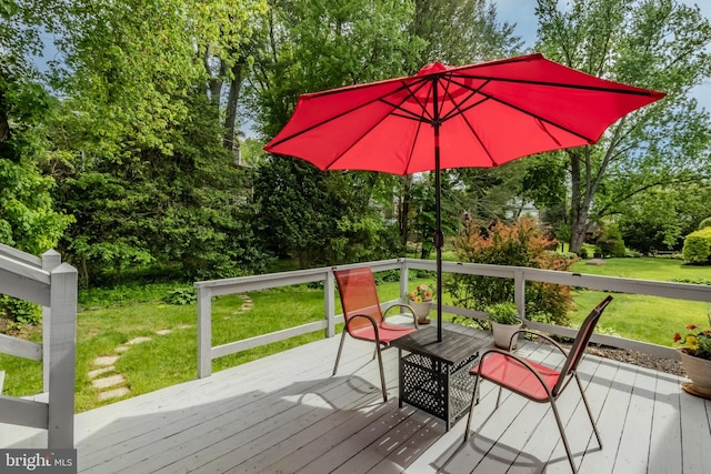 deck featuring a yard and view of wooded area