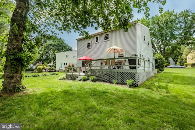 back of property with a deck and a lawn