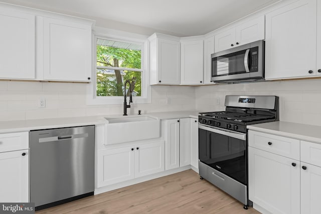 kitchen with appliances with stainless steel finishes, a sink, and backsplash
