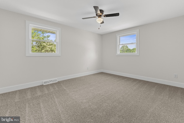 unfurnished room featuring plenty of natural light, baseboards, and carpet flooring