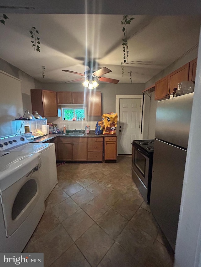 kitchen featuring appliances with stainless steel finishes, brown cabinets, a ceiling fan, a sink, and dark countertops