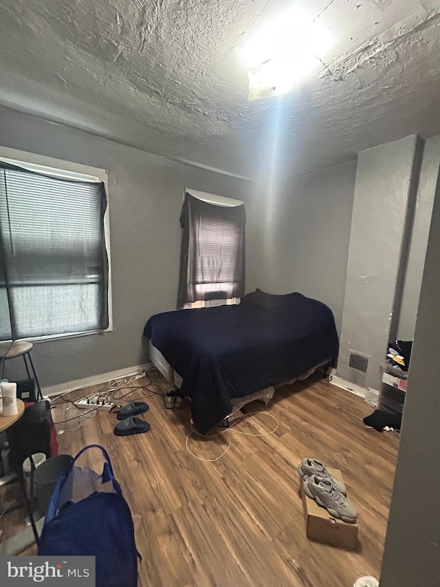 bedroom with wood finished floors and baseboards