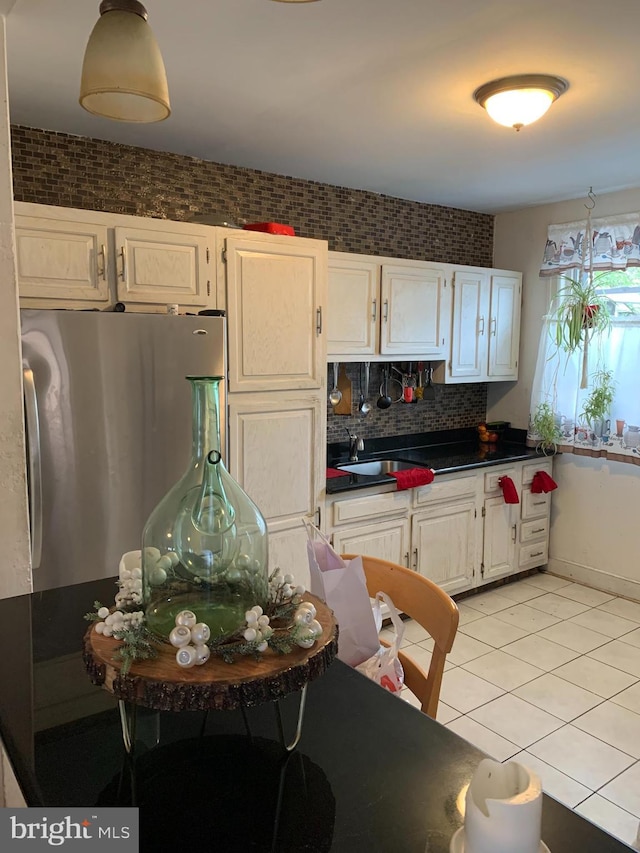 4808 Gransback St, Philadelphia, PA 19120 - kitchen with freestanding refrigerator, light tile patterned floors, dark countertops, decorative backsplash, and white cabinetry