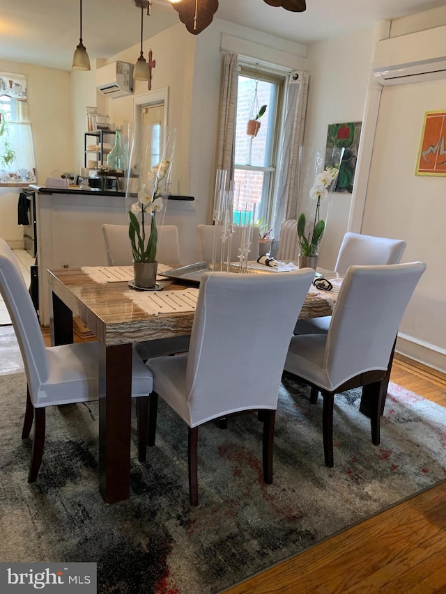 4808 Gransback St, Philadelphia, PA 19120 - dining area with a wall unit AC, plenty of natural light, and wood finished floors