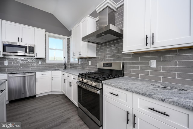 1308 E Bay Ave, Manahawkin, NJ 08050 - kitchen with stainless steel appliances, wall chimney exhaust hood, lofted ceiling, white cabinetry, and light stone counters