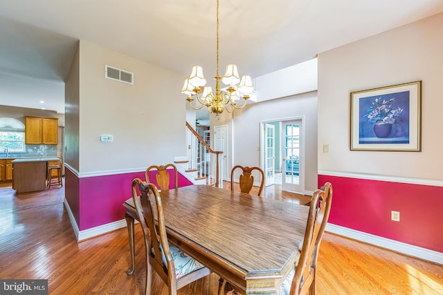 dining space with light wood-style flooring, stairs, and plenty of natural light