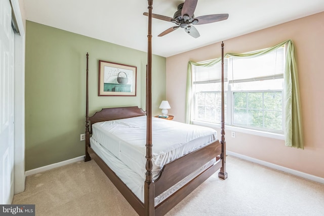 bedroom featuring light colored carpet, baseboards, and ceiling fan