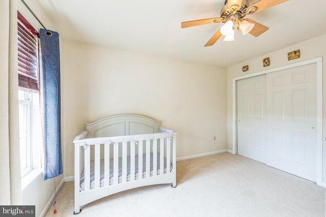 carpeted bedroom with multiple windows, baseboards, and a ceiling fan