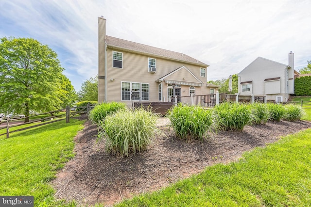 rear view of property featuring a covered hot tub and a chimney