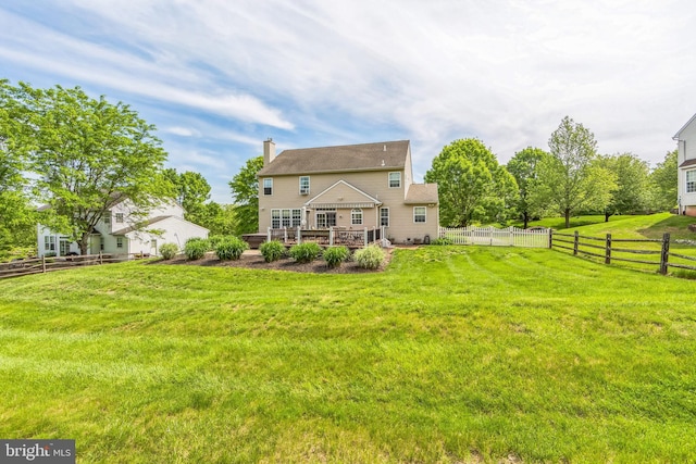 rear view of property featuring a deck and a chimney