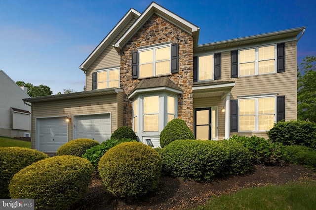 view of front of home with stone siding and an attached garage