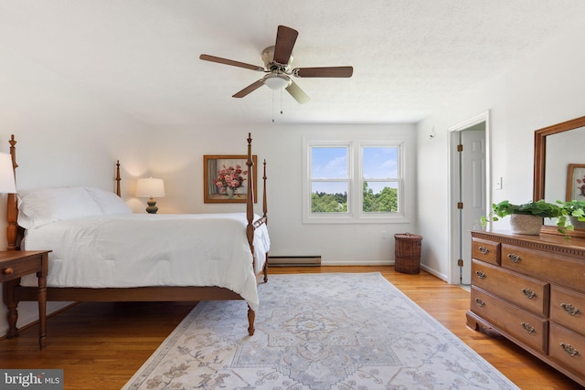 190 Chrismore Rd, White Post, VA 22663 - bedroom with a baseboard heating unit, light wood-style flooring, and ceiling fan