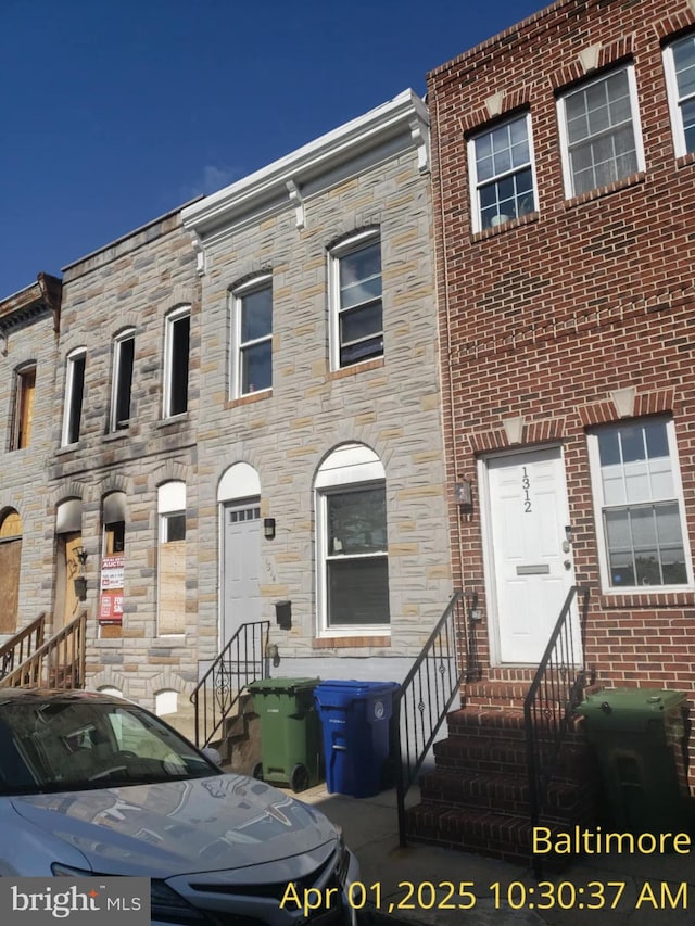 townhome / multi-family property with entry steps and stone siding