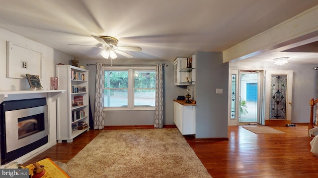 8609 N Dr, Clinton, MD 20735 - kitchen with a glass covered fireplace, ceiling fan, dark wood-style floors, and baseboards