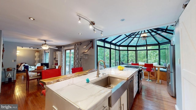 8609 N Dr, Clinton, MD 20735 - kitchen featuring appliances with stainless steel finishes, hardwood / wood-style floors, a sink, a ceiling fan, and a sunroom