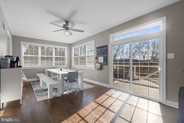 dining room with a ceiling fan, baseboards, and wood finished floors