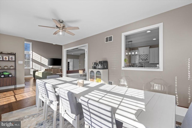 dining space with ceiling fan, wood finished floors, and baseboards
