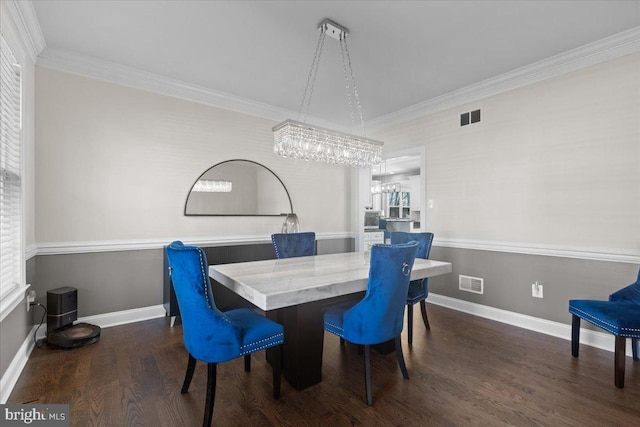 dining room with a chandelier, wood finished floors, ornamental molding, and baseboards