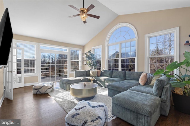 living area featuring ceiling fan, wood finished floors, high vaulted ceiling, and baseboards