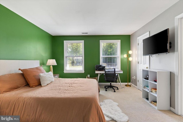 bedroom with carpet, baseboards, and an office area