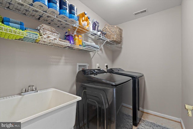 washroom with washer and clothes dryer, baseboards, and tile patterned flooring