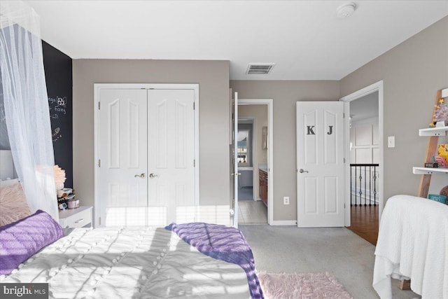 carpeted bedroom featuring a closet and baseboards