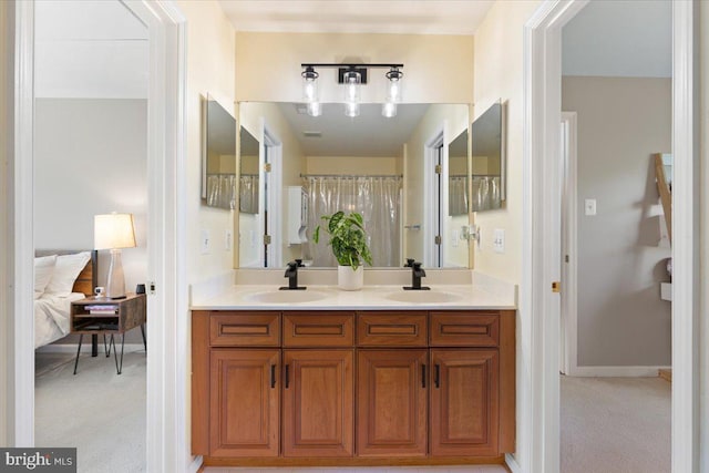 ensuite bathroom with double vanity and baseboards