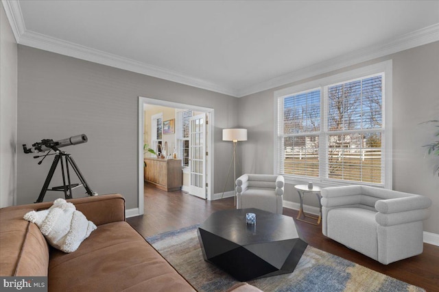living room featuring baseboards, crown molding, and wood finished floors
