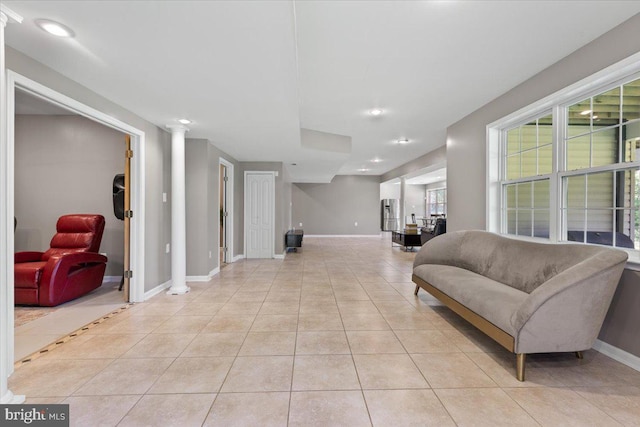 living area with baseboards, light tile patterned floors, ornate columns, and recessed lighting