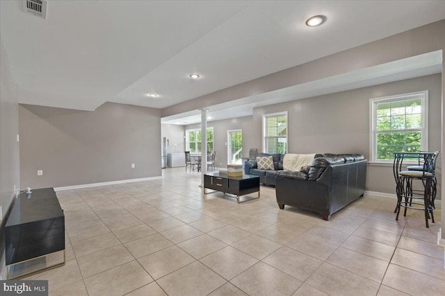 living room featuring light tile patterned flooring, baseboards, and recessed lighting