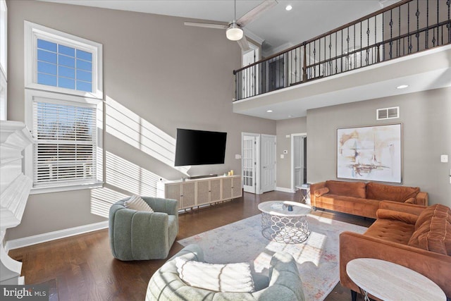 living area featuring baseboards, a high ceiling, wood finished floors, and ceiling fan