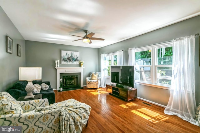 16068 Hayes Ln, Woodbridge, VA 22191 - living area with ceiling fan, wood finished floors, a fireplace with flush hearth, and baseboards